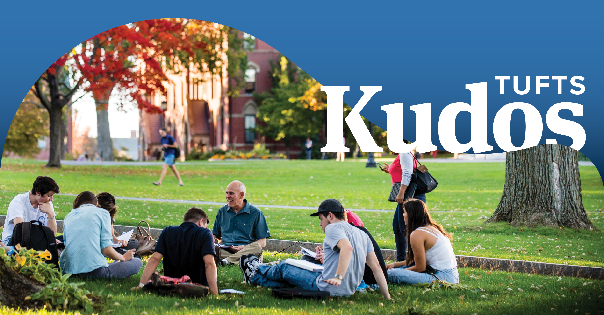 Students sitting with a professor outside on the Tufts campus. Words "Tufts Kudos" appear in the upper right of the photo.