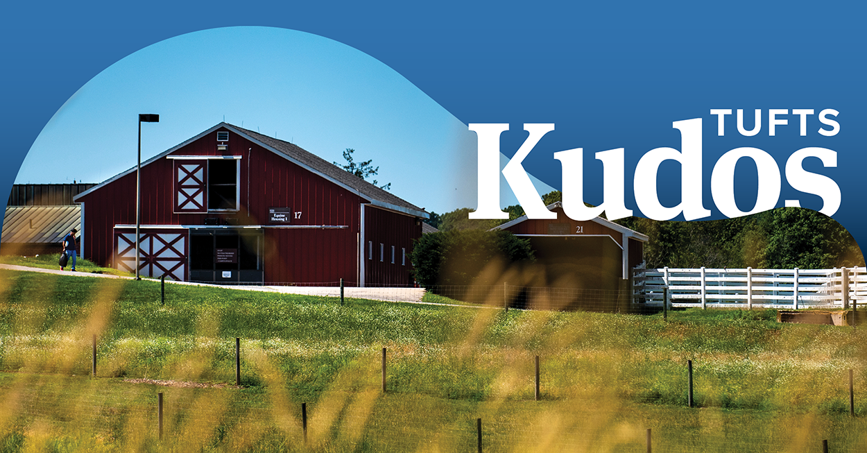 Cummings School red barn with field in the foreground. The words "Tufts Kudos" appear on upper right side of image over a blue banner.