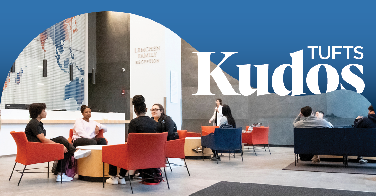 Students sitting at a table and talking to one another in the lobby of Tufts University School of Dental Medicine.